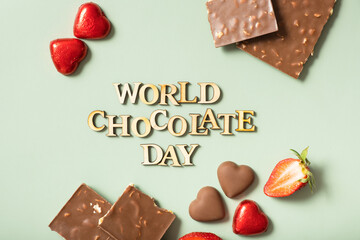 World chocolate day text with chocolate flat lay, top view on pastel green background