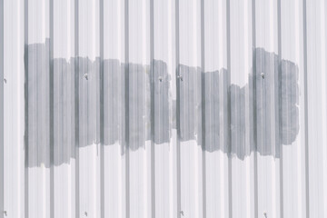 White metal corrugated fence painted with gray paint background