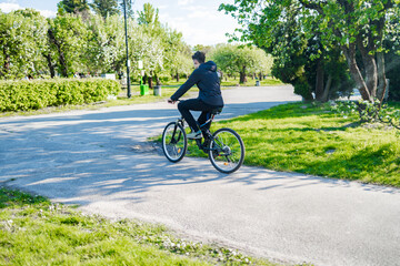 Handsome young man with bicycle in the park on a sunny day