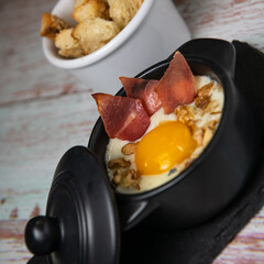 Recipe Oeuf cocotte with fresh cream sauce, Roquefort and walnuts, ham chips, toasted bread sticks. High quality photo