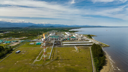 Oil refining factory with constructions and flare stacks. Ground tanks store oil and gas in an oil...