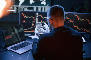 Financial Analyst Working on a Computer with Multi-Monitor Workstation with Real-Time Stocks,...