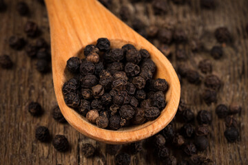 black pepper on wooden spoon