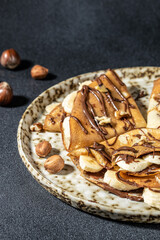 crepes with banana and chocolate. breakfast or dessert. vertical image. top view. place for text