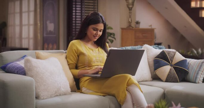 Beautiful Woman Engaged in Laptop Use at Home, does Work Projects, and Efficiently Leading Her Remote Team. Girl does Online Shopping, Seeking Out the Best Deals on Cosmetics and Fashion Items. Medium
