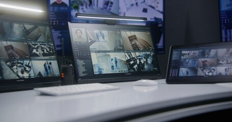 Video footage of surveillance CCTV cameras with biometric AI face scanning system displayed on computer monitors and tablet. Big digital screen with big data on background. Security monitoring center.