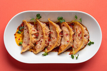 Portion of japanese gyoza dumplings on pink background