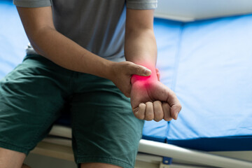 Physiotherapist examining patient's wrist by pressing on wrist bones in clinic room wrist joint...