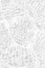 White water with ripples on the surface. Defocus blurred transparent white colored clear calm water surface texture with splashes and bubbles. Water waves with shining pattern texture background.
