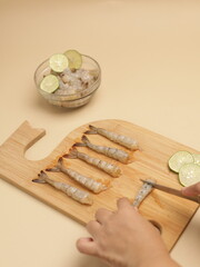 Raw prawns on wooden chopping board, ingredients for cooking