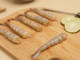 Raw prawns on wooden chopping board, ingredients for cooking