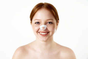 Portrait of young beautiful girl with bandage on her nose after rhinoplasty smiling, looking at...