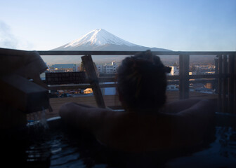 woman have a  hot spring in front of fuji