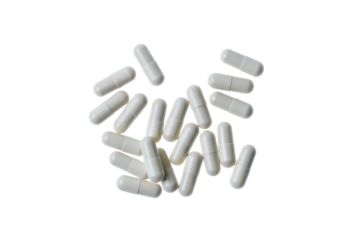 scattered pills in white capsules, on an isolated transparent background top view
