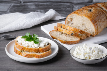 Sandwiches with cottage cheese and bread with olives on a gray table