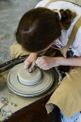 close up view of professional potter working on pottery wheel at workshop. High quality photo