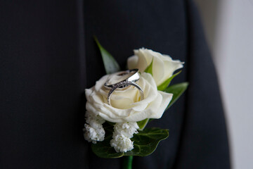 white wedding buttonhole with with wedding ring white gold with diamonds.
