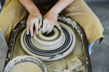 close up view of professional potter working on pottery wheel at workshop. High quality photo