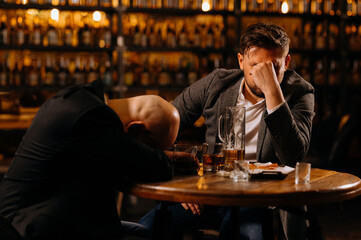 drunken men sleeping on a table in a pub after work. friends, colleagues, drink alcohol