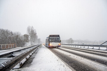 Naklejka na ściany i meble Bus driving in a snow storm in Noord Holland the Netherlands