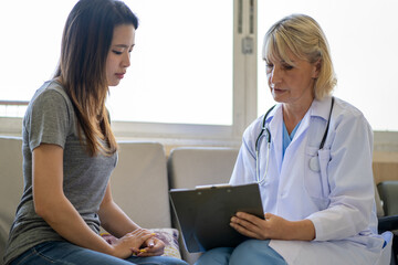 Professional psychiatrist listening to her patient in medical clinic or hospital mental health...