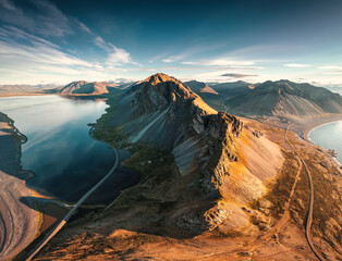 Mount Eystrahorn with Krossasnesfjall mountain range and sunlight shining on coastline in summer at...