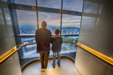 Eine junge Frau und ein Kind betrachten aus einem Fahrstuhl das Panorama