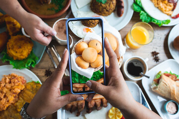 Crop anonymous female photographic traditional Latin American dishes in restaurant
