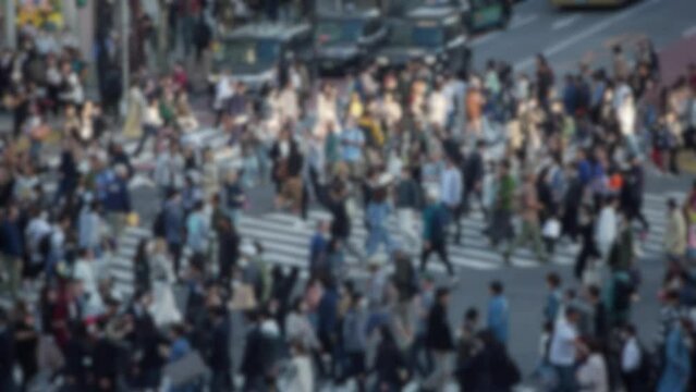 Blurred defocused slow motion of aerial view of walking through the iconic Shibuya Crossing, the midst of a massive crowd can be overwhelming. With such a high concentration of people.