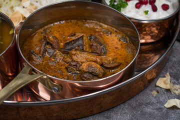 Mushroom and eggplant curry in copper serving bowl