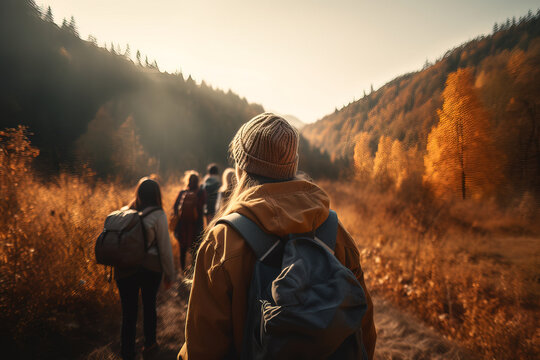 Generative AI illustration of back view of group of hikers with backpacks walking in woods with colorful trees during sunset in autumn