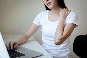 Naklejka premium Tired stressed Asian business woman suffering from disorder characterized neck pain after working in home office. Overworked and hard working