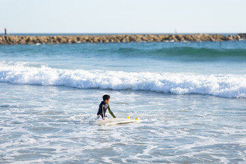 A little boy surfer in the sea