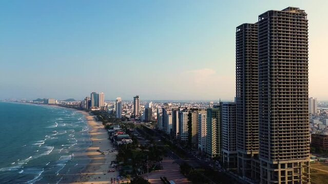 Aerial 4K footage of Da Nang coastline. My Khe beach seafront with high-rise hotels and skyscrapers in the golden sand beach