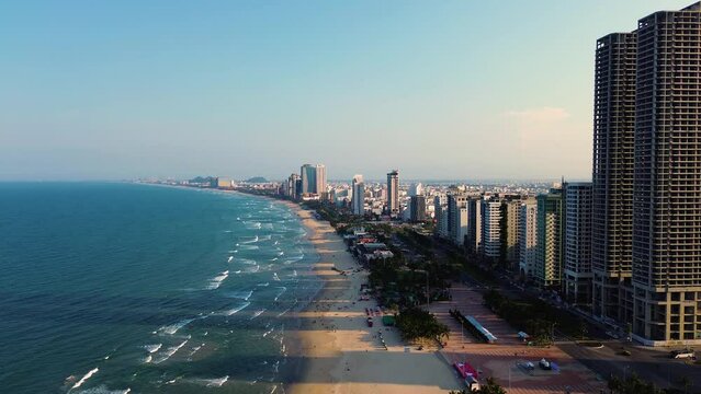 Aerial 4K footage of Da Nang coastline. My Khe beach seafront with high-rise hotels and skyscrapers in the golden sand beach