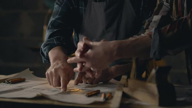 Wood, Men Concentrated Two fellow workers studying drawings of wooden parts for manufacturing In the workroom Concept Woodworker Spends working time studying new ideas Workplace, workroom
