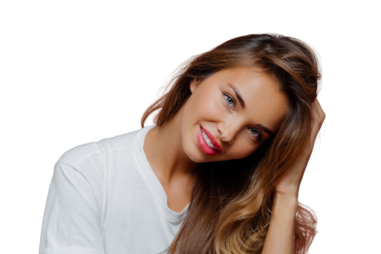 Portrait of good looking pleased female model tilts head, has toothy smile shows white perfect teeth, wears casual jumper, touches hair, shows her beauty, being in good mood, isolated on purple wall