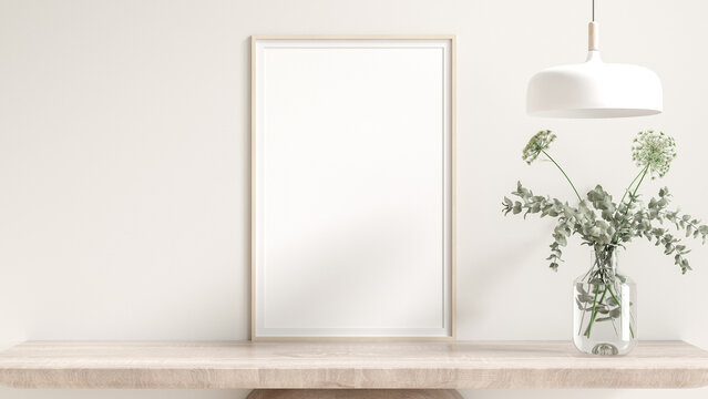 Blank wooden poster frame mockup. placed on a wooden cabinet furniture. Flowers in glass vases, and lamp. White room background, cream, and natural light from the window. 3D render