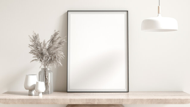 Blank black poster frame mockup. placed on a wooden cabinet furniture dried flowers in glass vases, sculpture, and lamp. White room background, cream, and natural light from the window. 3D render