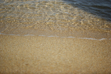 Sea water rushes into the sandy beach