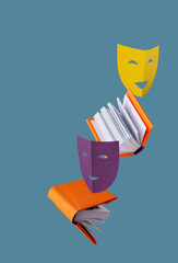 Fototapeta colored theatrical masks and books fly on a blue background, copy space obraz