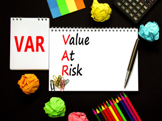 VAR Value at risk symbol. Concept words VAR Value at risk on beautiful white note. Beautiful black table black background. Calculator. Business and VAR Value at risk concept. Copy space.