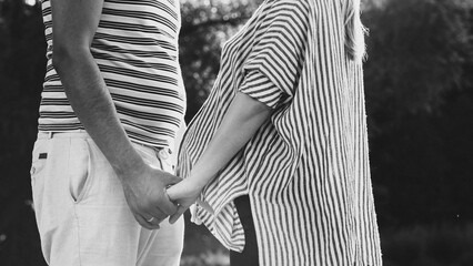 Pregnant woman with husband standing holding hand care together. The concept of pregnancy. Happy...