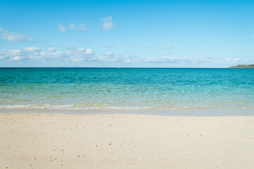 Fototapeta na wymiar Empty white sandy beach with blue sky and white clouds