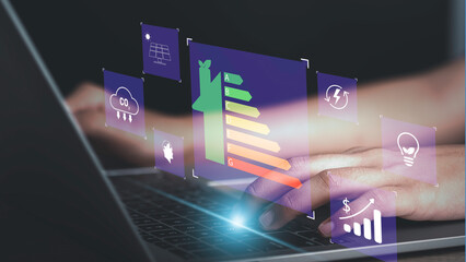 Energy efficiency rating and eco green home concept. Hand use laptop computer with house icon energy efficiency. Ecology house with low consumption on renovation with insulation. Show save cost icon.