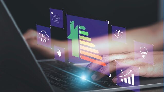 Energy efficiency rating and eco green home concept. Hand use laptop computer with house icon energy efficiency. Ecology house with low consumption on renovation with insulation. Show save cost icon.