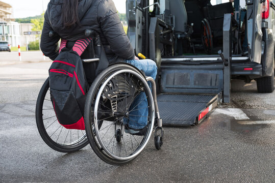 Woman on wheelchair using accessible car lift for people with disability.