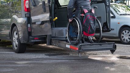 Woman on wheelchair using accessible car lift for people with disability.