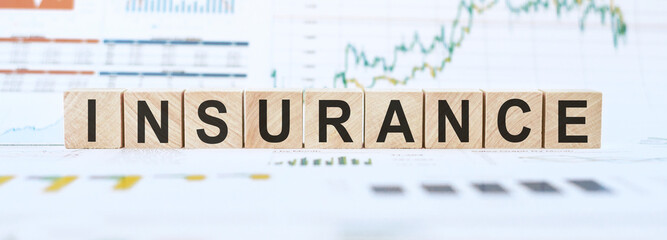 Insurance word made from wooden blocks on financial background