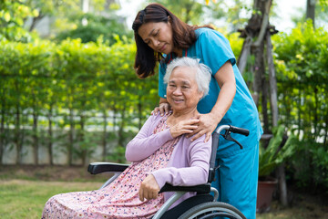 Doctor help and care Asian senior woman patient sitting on wheelchair at park in nursing hospital ward, healthy strong medical concept.